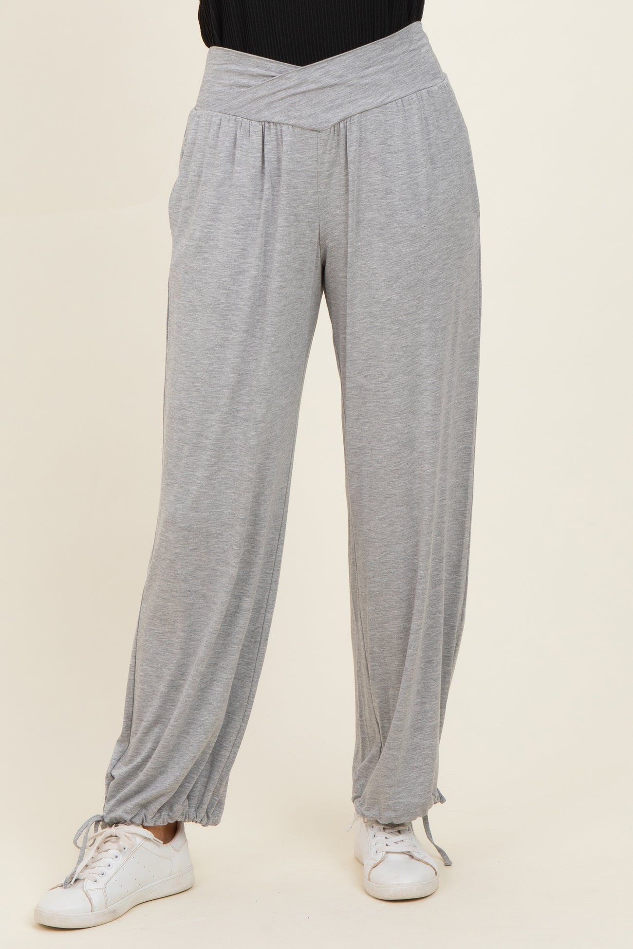 woman wearing light gray wide-leg lounge pants with a ruched hem and a stylish high waistband