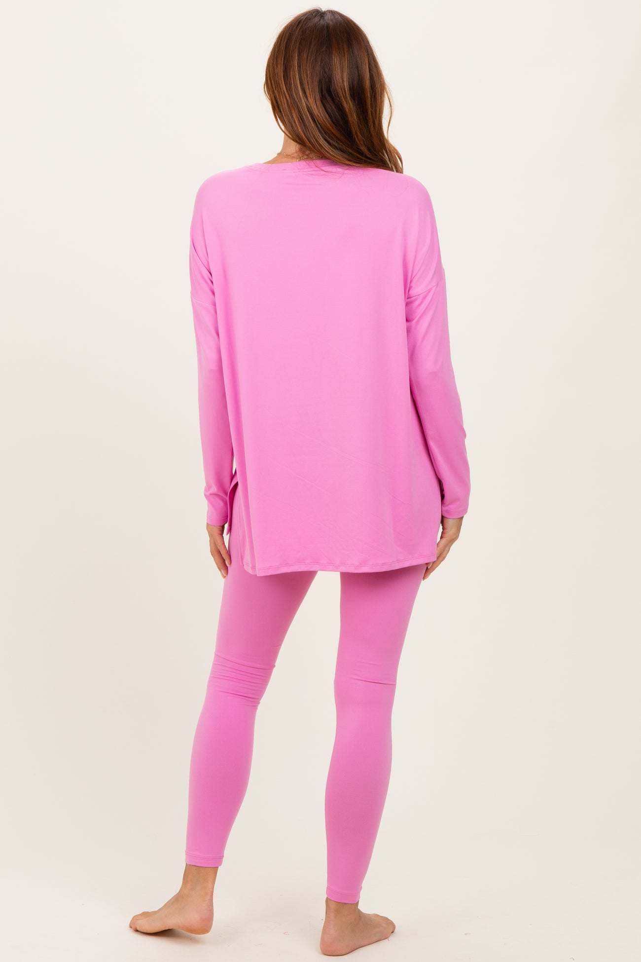 woman wearing a long sleeve pink top and matching pink leggings, viewed from the back