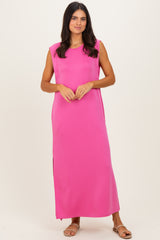 woman wearing a bright pink sleeveless maxi dress with side slits and a relaxed fit