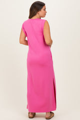 woman wearing a bright pink maternity maxi dress with side slits and a relaxed fit, showing her baby bump from the side