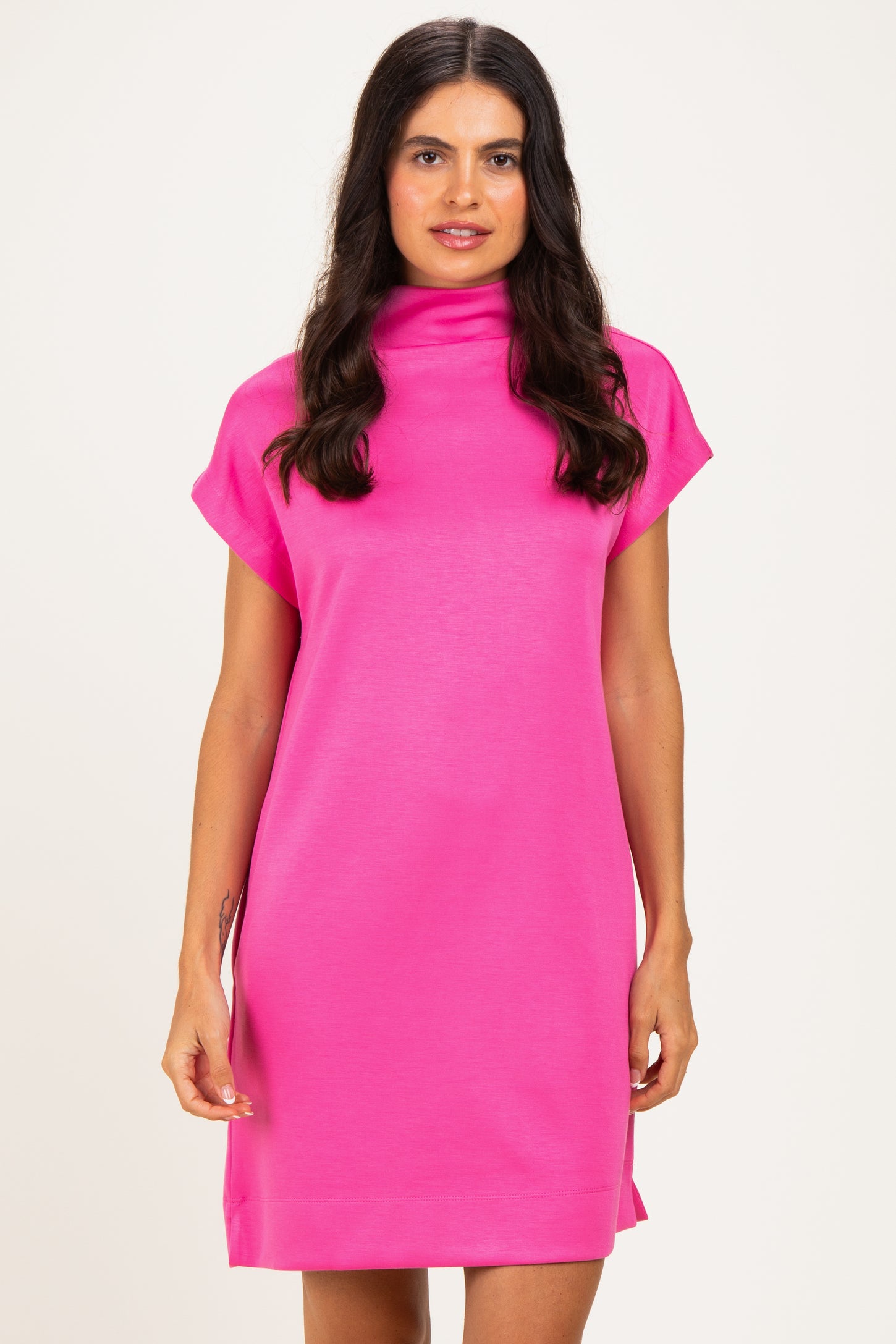 woman wearing a pink short sleeve dress with a high neckline and relaxed fit