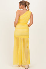woman wearing a yellow one-shoulder maternity maxi dress with ruching and flowing bottom, showing her baby bump