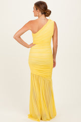 woman wearing a yellow one-shoulder ruched evening gown with a flowing skirt seen from the back