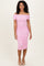 woman wearing a pink off-the-shoulder ruched bodycon dress with a fitted silhouette and knee-length hem