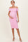 woman wearing a pink off-the-shoulder maternity dress with ruching and holding her baby bump