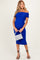 woman wearing a royal blue off-the-shoulder maternity dress with ruched detailing and holding a silver handbag, showing her baby bump