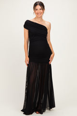 woman wearing a black one-shoulder maternity gown with a fitted bodice and flowy sheer skirt