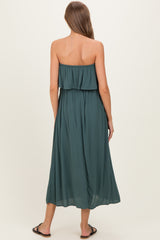 woman wearing a green strapless maternity maxi dress, showing a flowy silhouette and back view