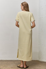 woman wearing a yellow and white striped maxi dress with short sleeves and side slit, viewed from the back