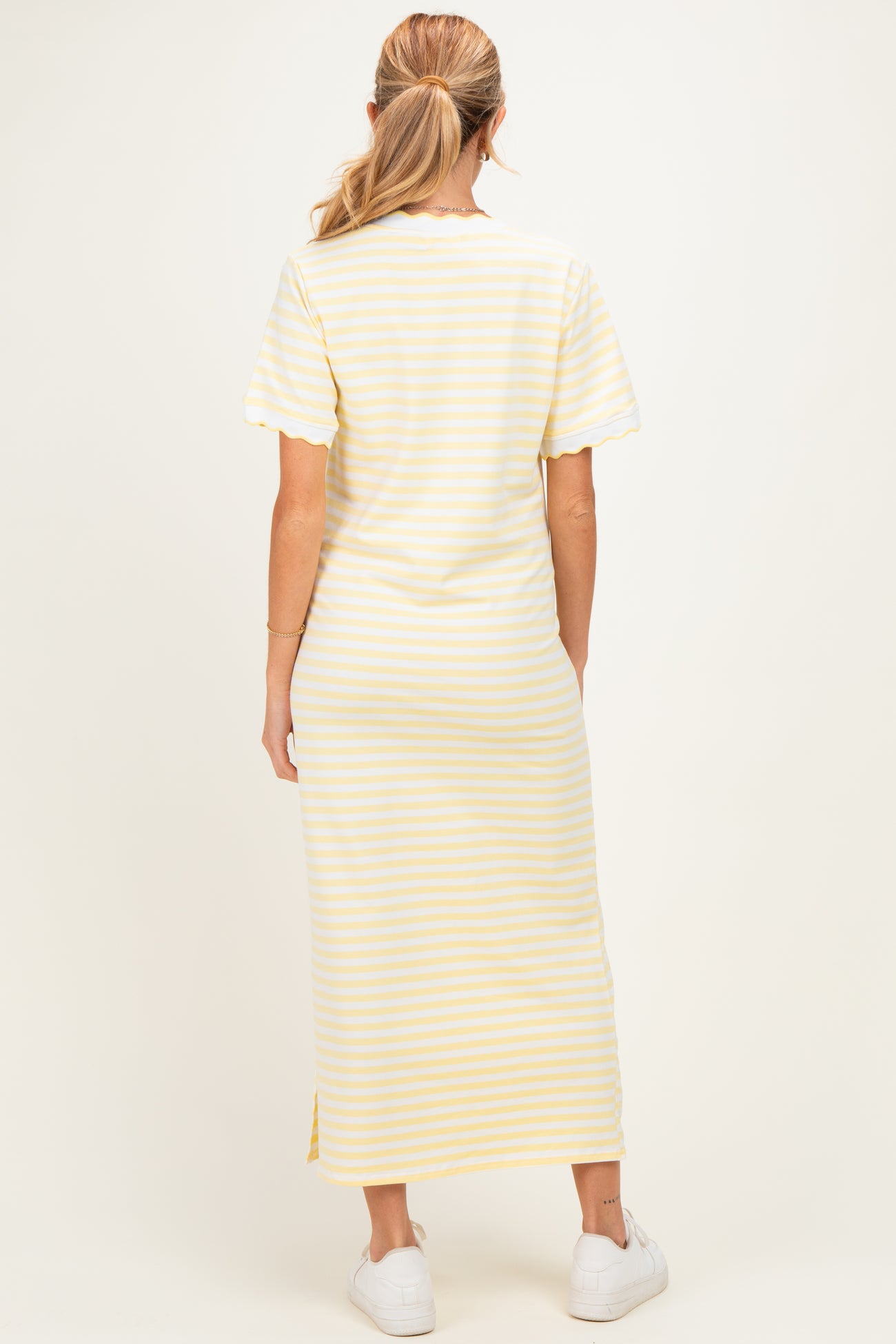 woman wearing a yellow and white striped maternity maxi dress, short sleeves, viewed from the back