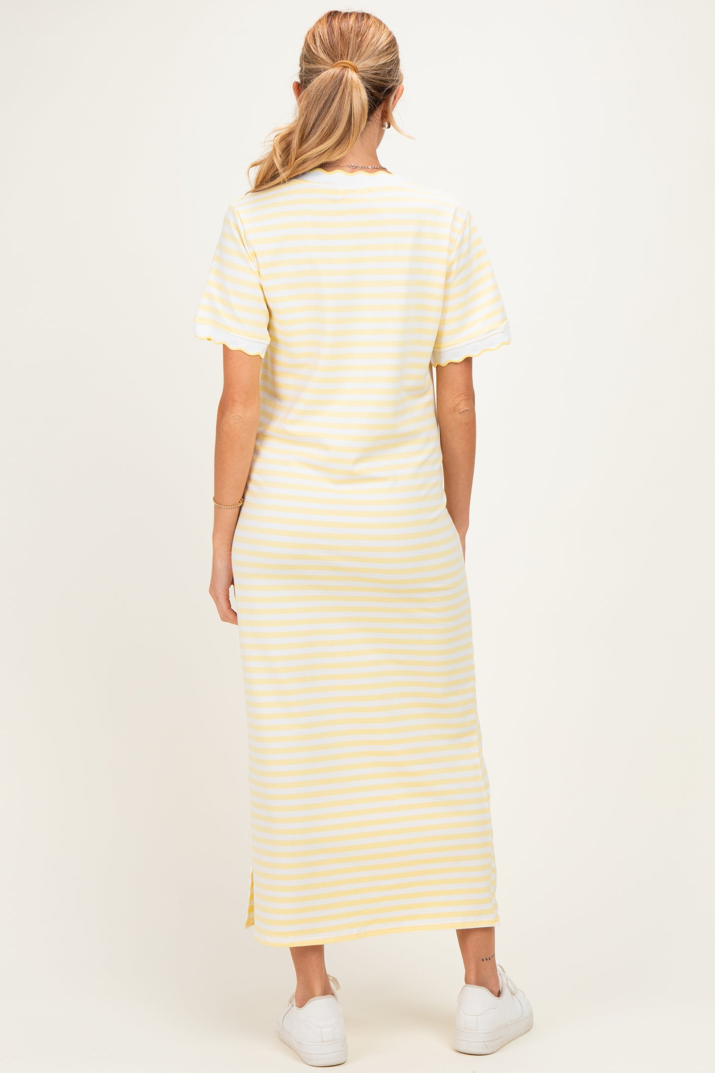 woman wearing a yellow and white striped maternity maxi dress, short sleeves, viewed from the back
