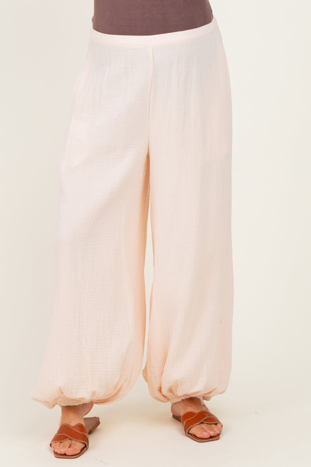 woman wearing loose-fitting light pink maternity pants with elasticized hem and a comfortable waistband