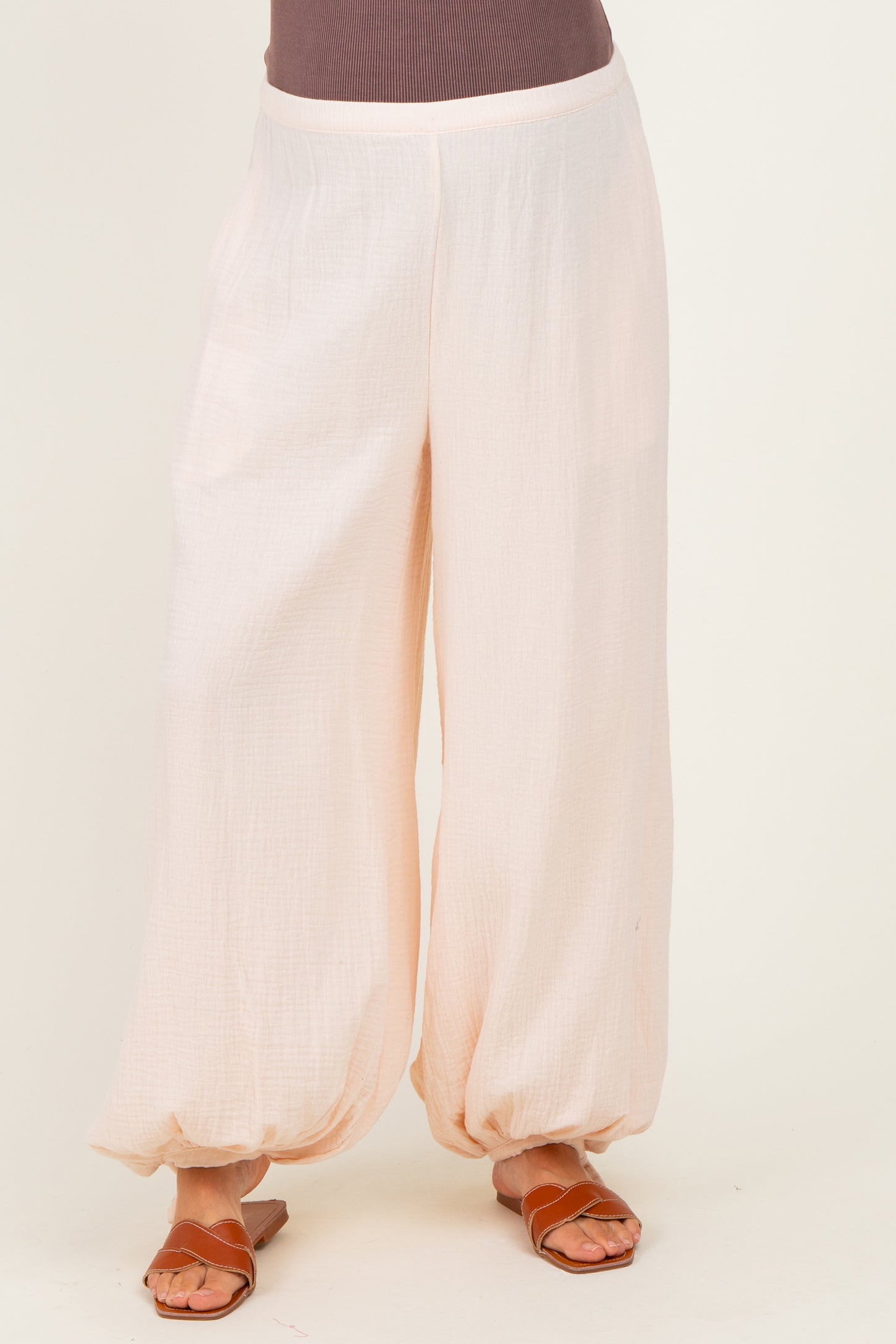 woman wearing loose-fitting light pink maternity pants with elasticized hem and a comfortable waistband