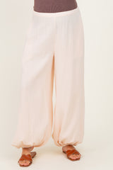 woman wearing loose-fitting light pink maternity pants with elasticized hem and a comfortable waistband