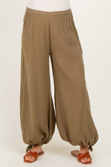 maternity wear in olive green wide-leg pants with gathered ankles, styled with brown sandals