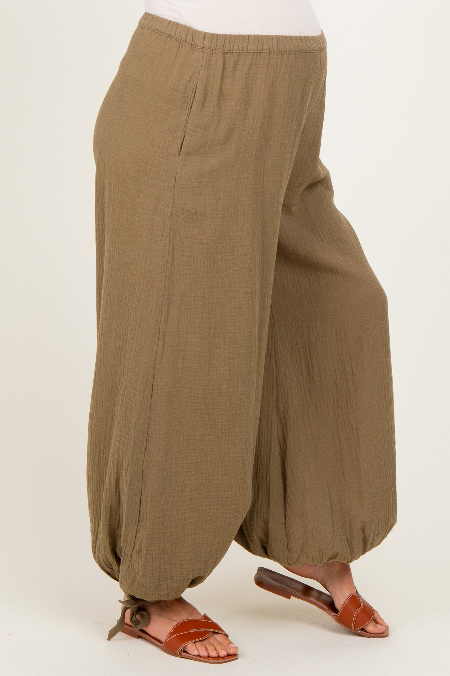 woman wearing a brown maternity harem pant with an elastic waistband and loose fit, showing a baby bump