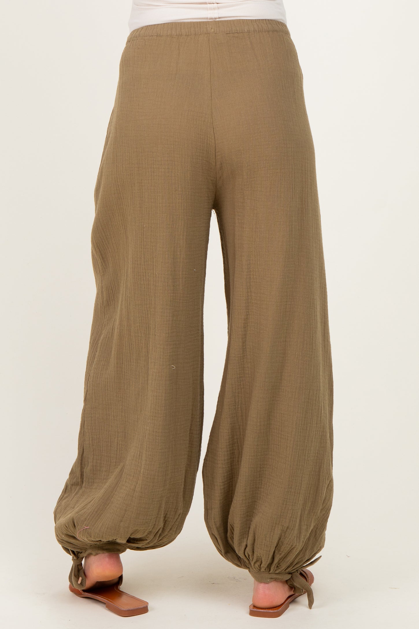woman wearing olive green maternity palazzo pants with a relaxed fit and gathered hem details