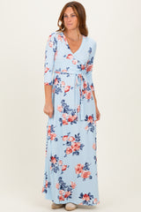 woman wearing a light blue floral wrap maxi dress with three-quarter sleeves and a tie waist