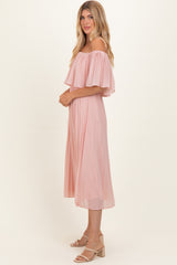 woman wearing a light pink off-the-shoulder pleated midi dress with flowing sleeves and a relaxed fit