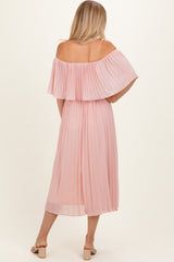 woman wearing a light pink off-the-shoulder pleated dress, shown from the back