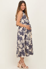 woman wearing a cream floral maternity dress with a flowing silhouette and a visible baby bump