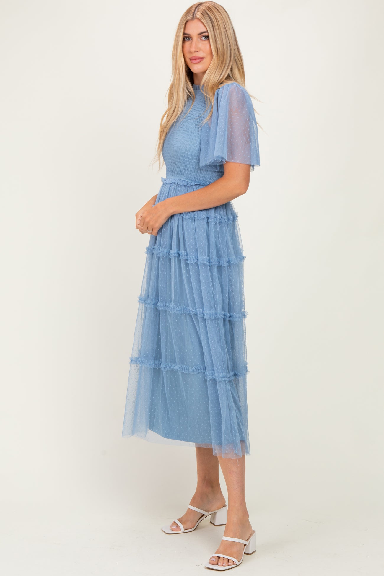 woman wearing a light blue tiered tulle midi dress with short sleeves and a fitted bodice