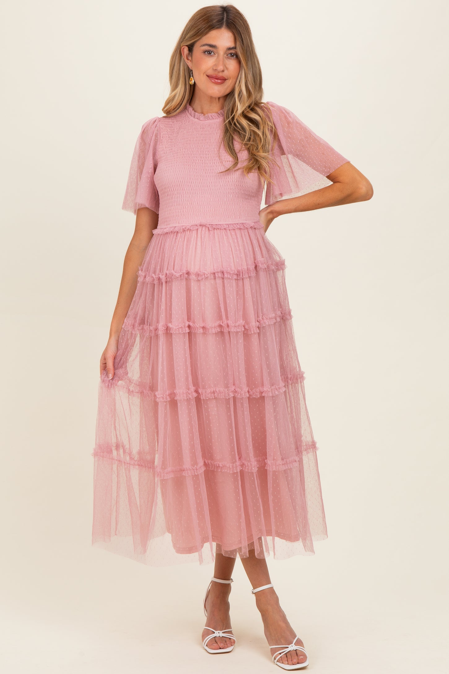 woman wearing a pink maternity maxi dress with tiered tulle layers and short puff sleeves