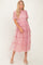 woman wearing a pink tiered tulle midi dress with puff sleeves and a fitted bodice
