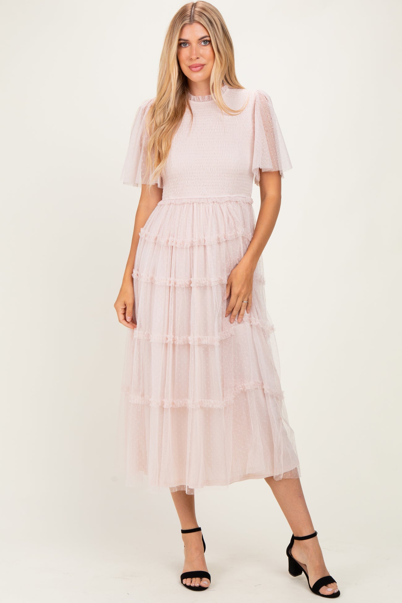woman wearing a pink tiered tulle midi dress with short puff sleeves and a smocked bodice