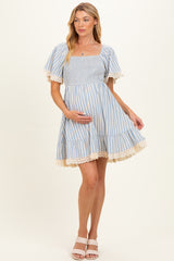 woman wearing a blue and white striped maternity dress with short sleeves and lace trim, showing her baby bump