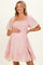 woman wearing a pink and white striped maternity dress with smocked bodice and lace trim on sleeves and hem