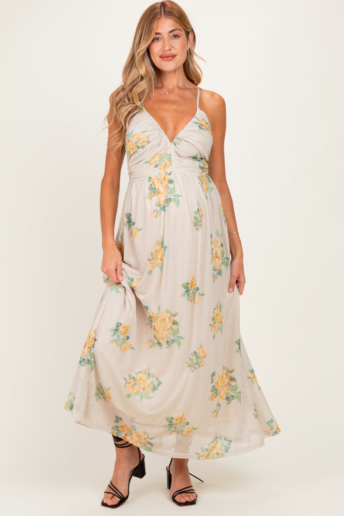 woman wearing a floral maternity maxi dress with a plunging neckline and adjustable straps