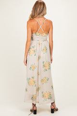 woman wearing a floral print maternity maxi dress with a crisscross back and gathered waist, showing her baby bump