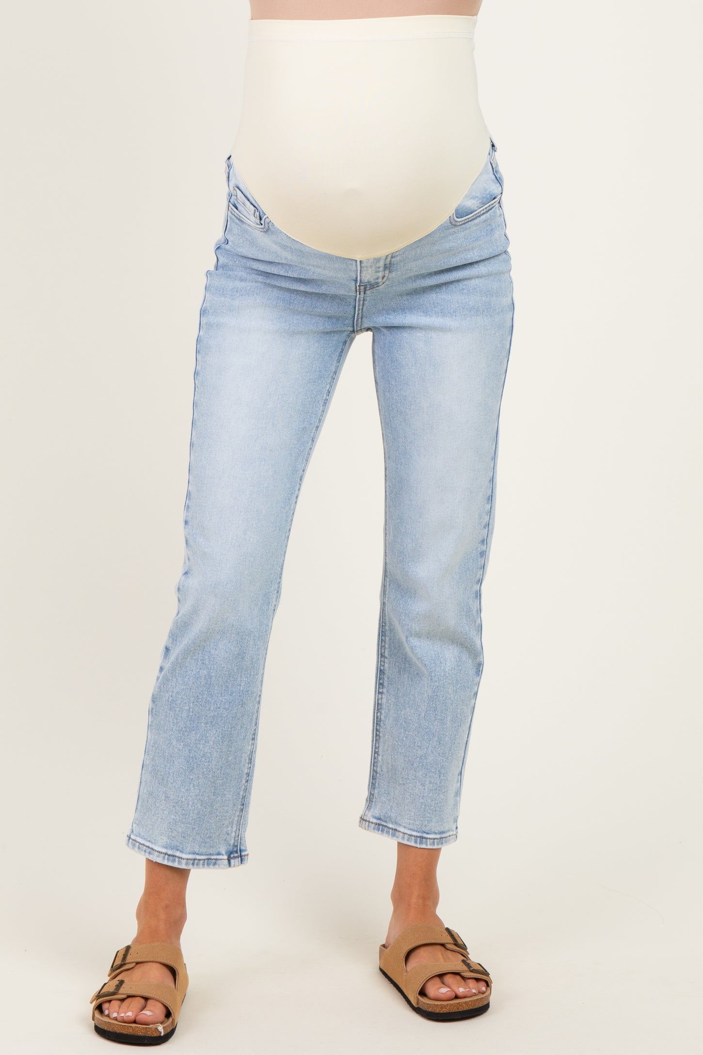 woman wearing light blue maternity jeans with a supportive belly band and a cropped flared leg style