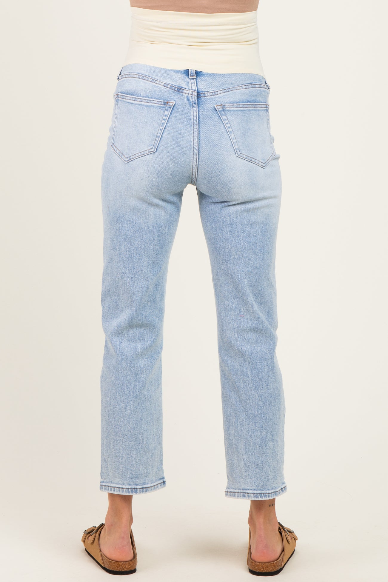 woman wearing light wash maternity jeans with a stretchy waistband, showing the back view