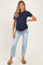 woman wearing a navy blue ribbed short sleeve maternity top and light blue jeans, showing her baby bump