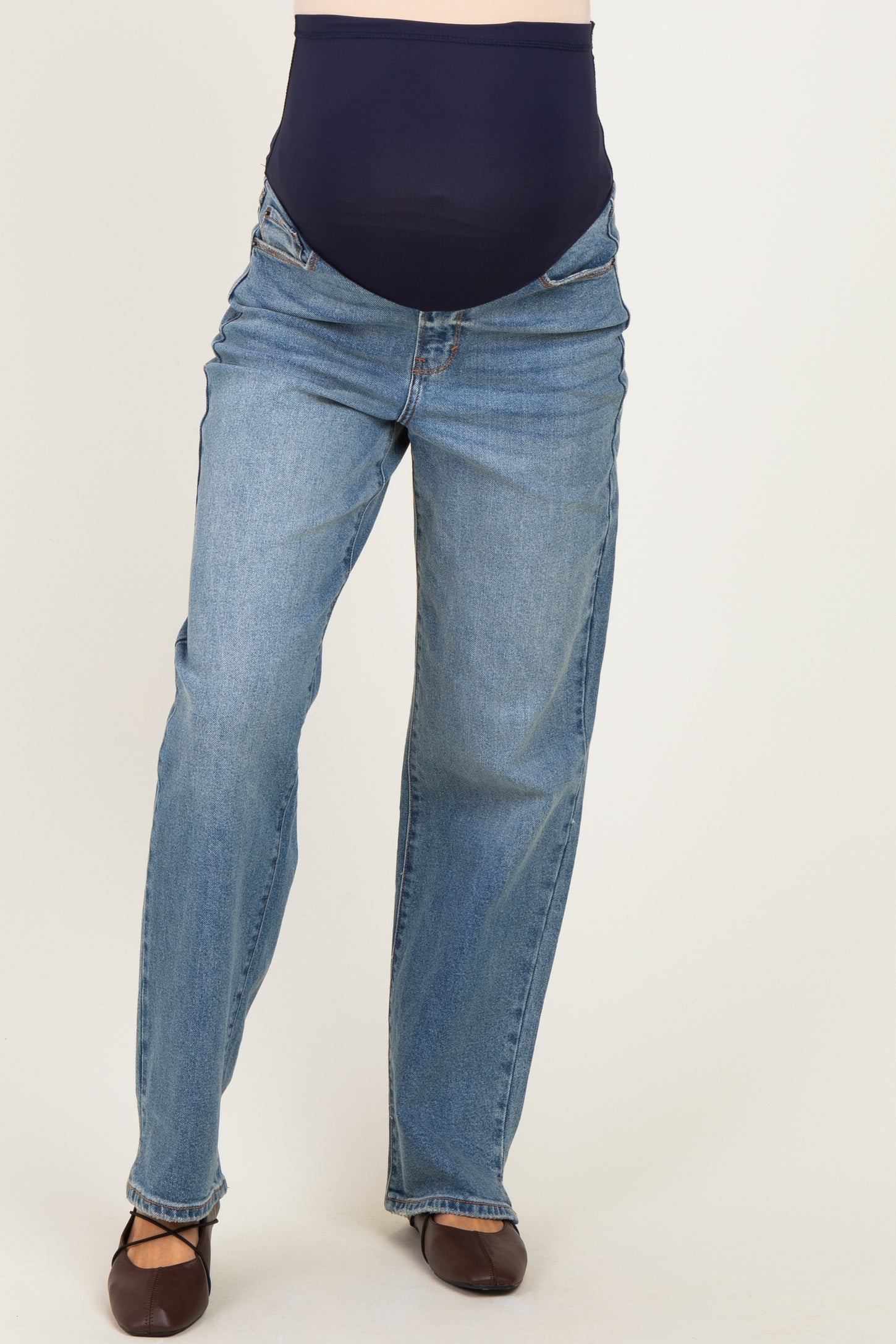 woman wearing maternity light wash straight leg jeans with a navy blue over-the-bump panel