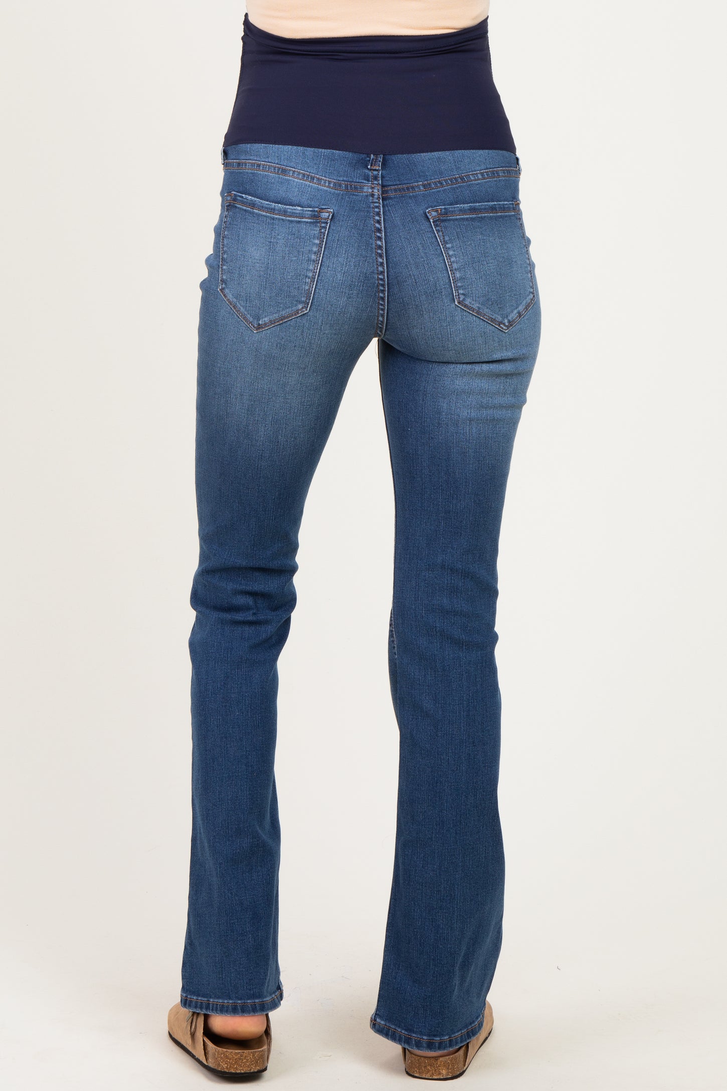 woman wearing blue maternity jeans with a stretchy waistband, viewed from the back