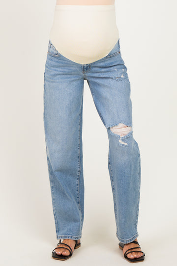 woman wearing distressed light blue maternity jeans with a supportive belly panel