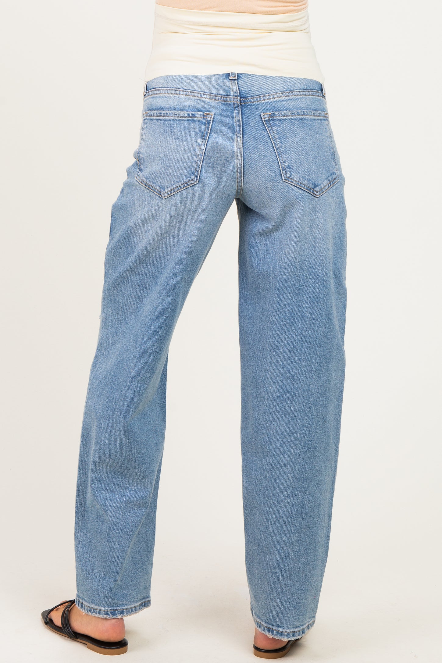woman wearing light blue maternity jeans with a relaxed fit, shown from the back