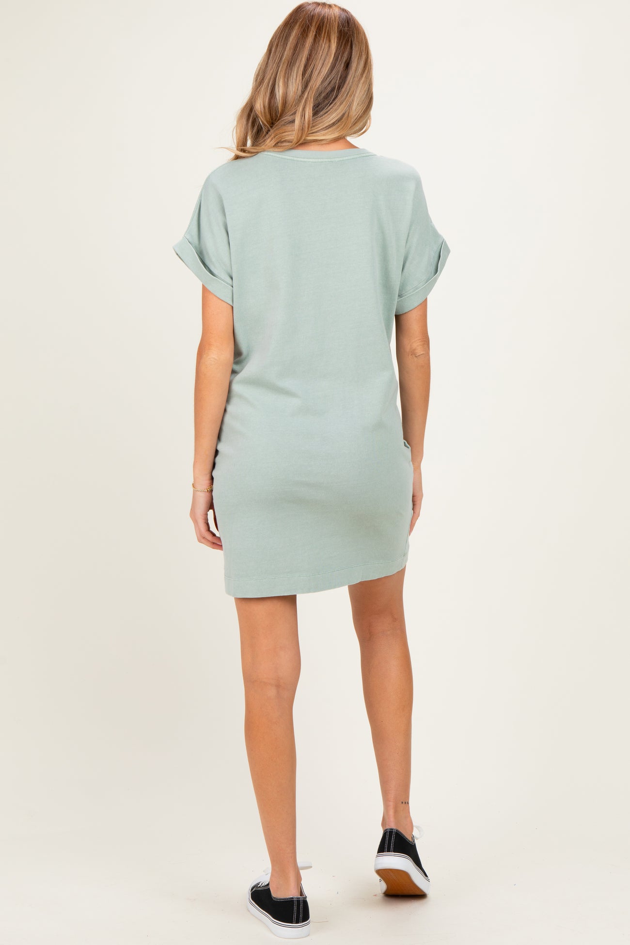 woman wearing a mint green short sleeve maternity dress, view from the back