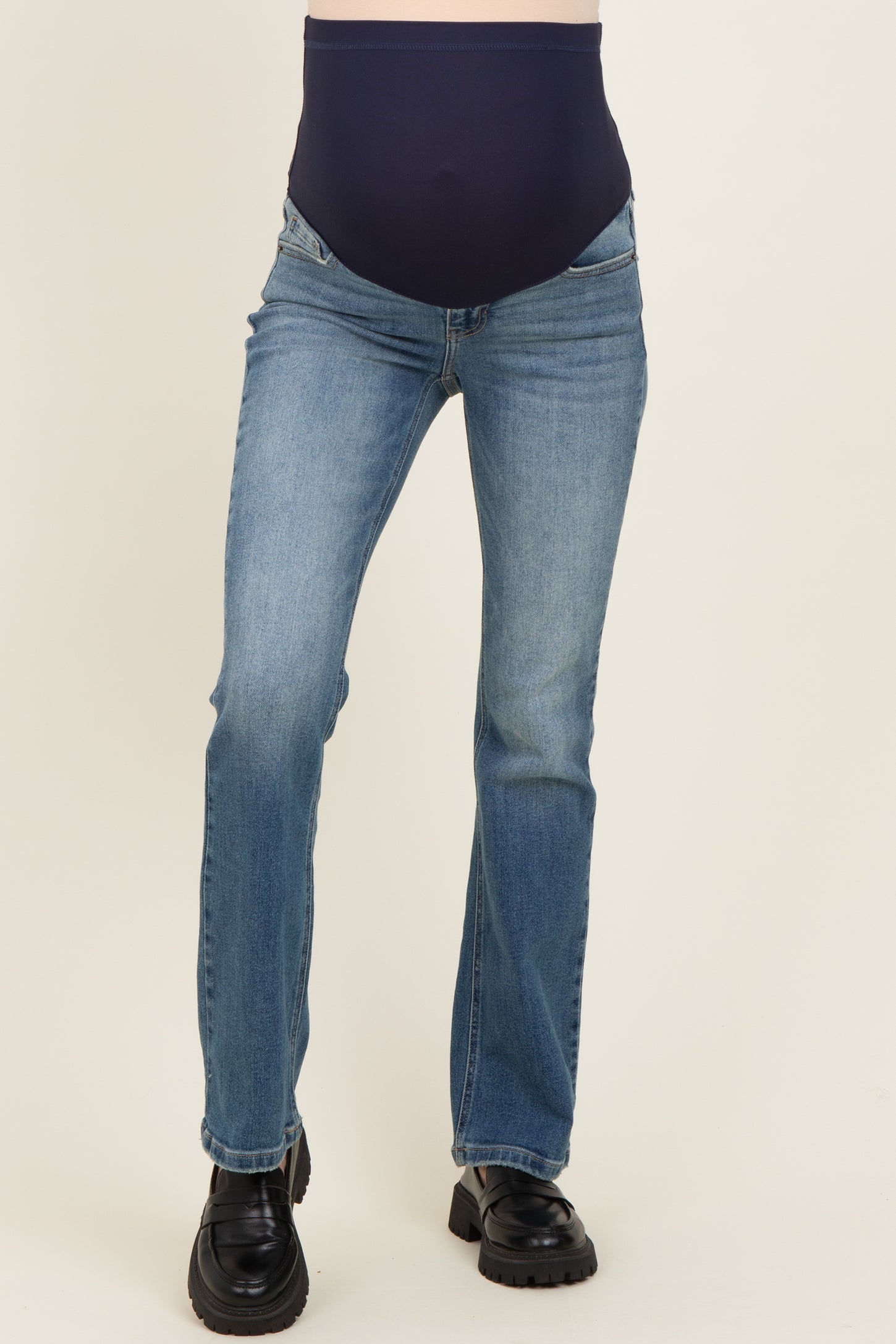 woman wearing a dark blue maternity jean with a high waistband and blue denim style
