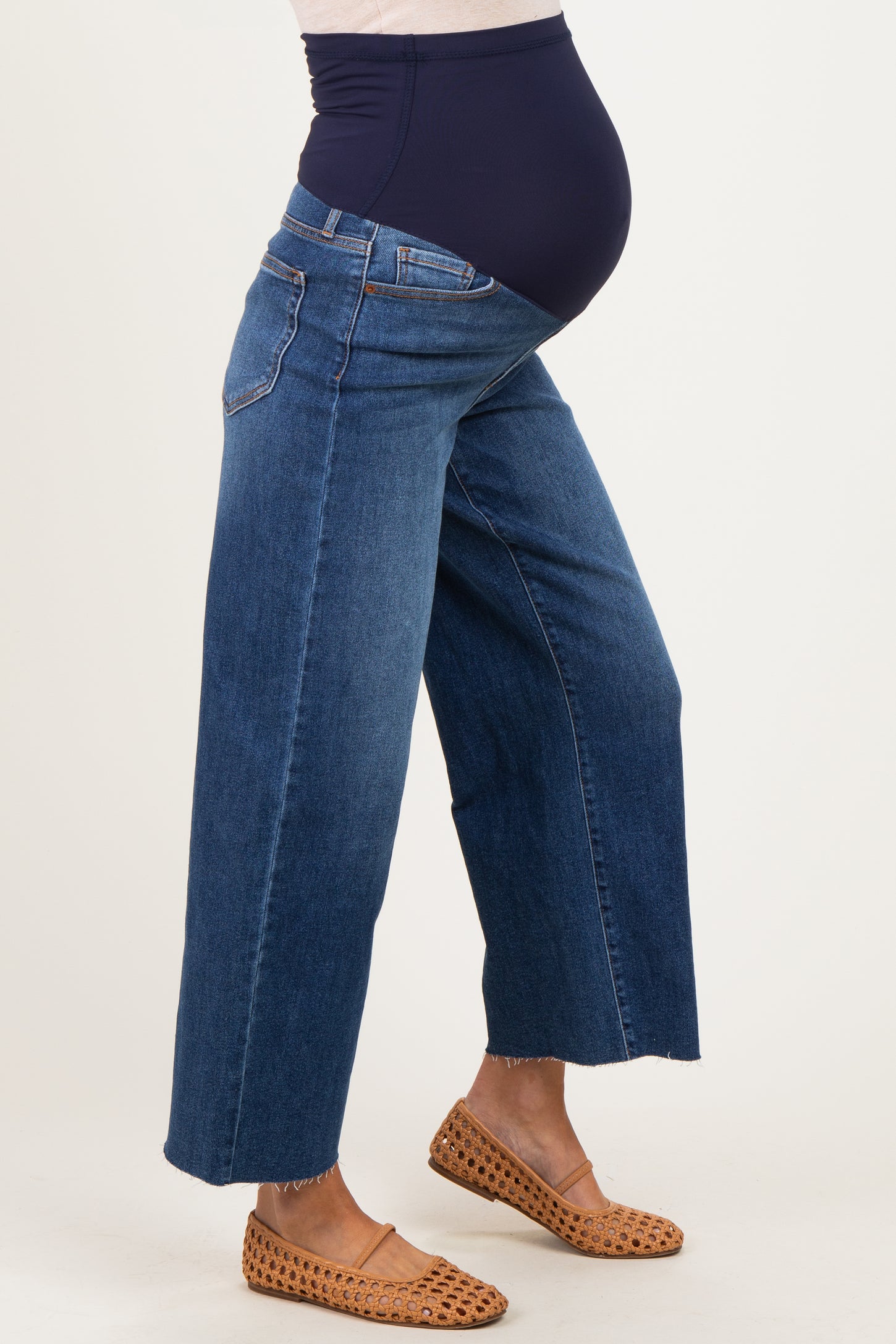 woman wearing dark blue maternity wide-leg jeans with a stretchy waistband and visible baby bump