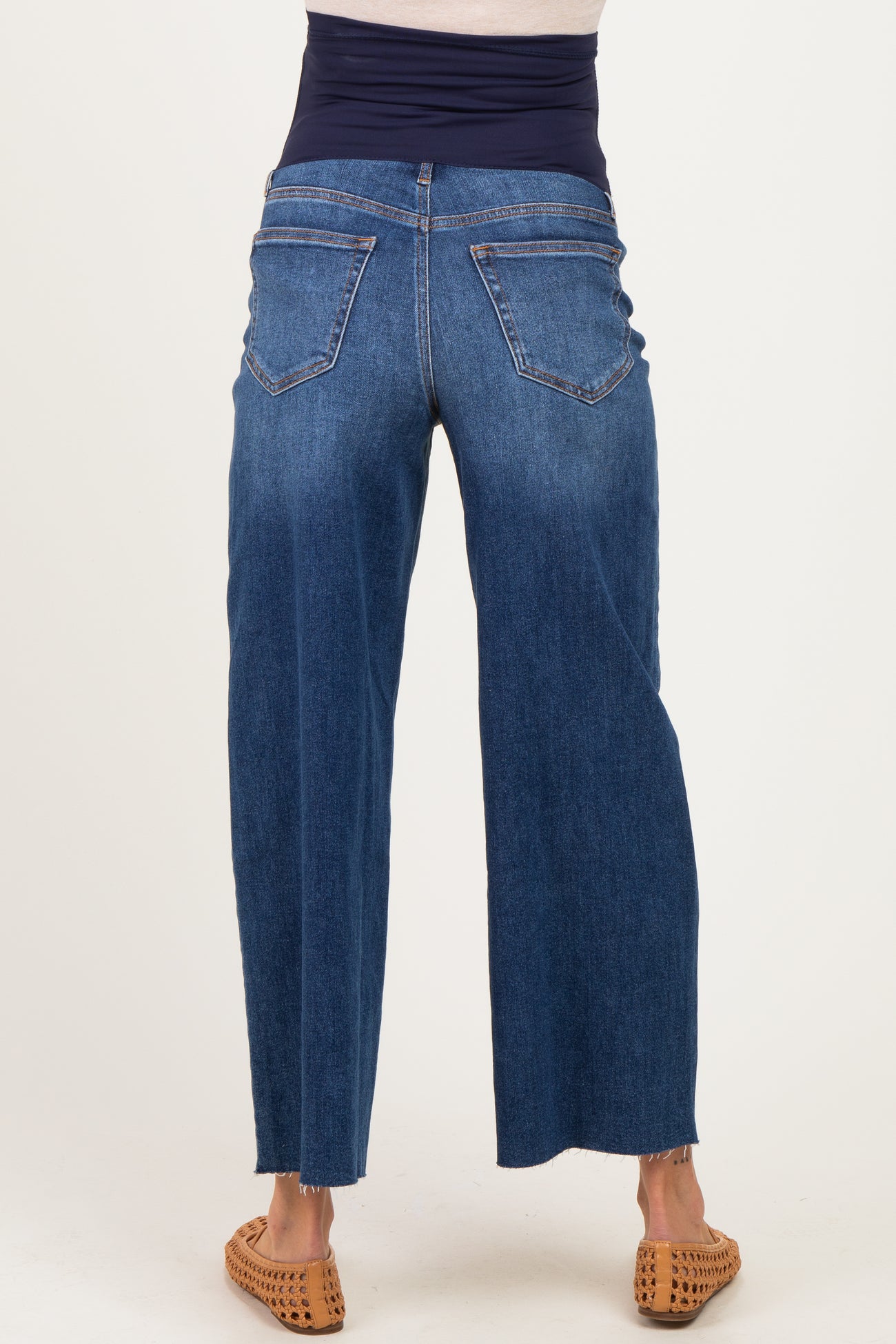 woman wearing indigo maternity jeans with a wide-leg cut and a stretchy waistband, showing the back view