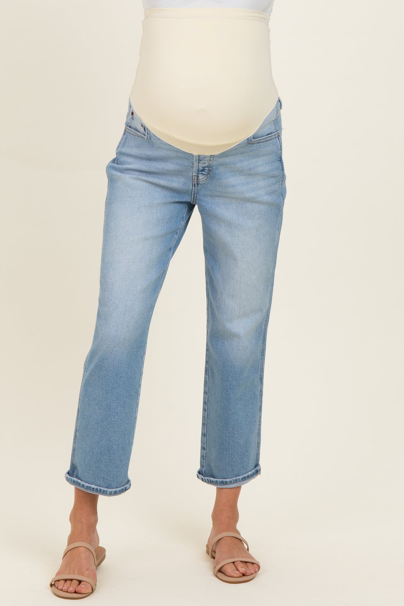 woman wearing light blue maternity jeans with a stretchy belly panel and rolled cuffs, showcasing a baby bump
