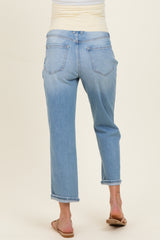 woman wearing light wash maternity jeans with a relaxed fit and rolled cuffs, showing the back view