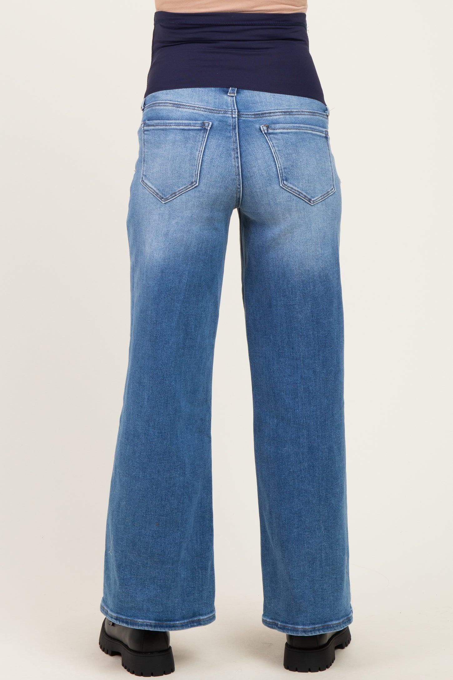 woman wearing blue maternity wide-leg jeans with a dark blue over-the-bump waistband view from the back