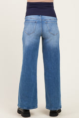 woman wearing blue maternity wide-leg jeans with a dark blue over-the-bump waistband view from the back