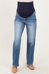 woman wearing a pair of light blue maternity jeans with a navy over-the-bump panel and a straight leg cut