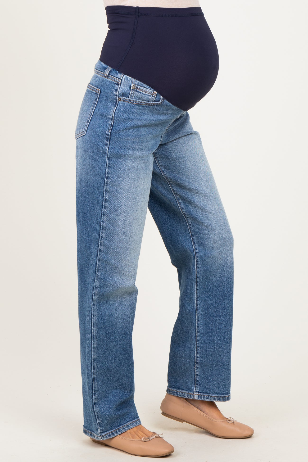 woman wearing blue maternity jeans with a stretchy navy waistband, showing her baby bump